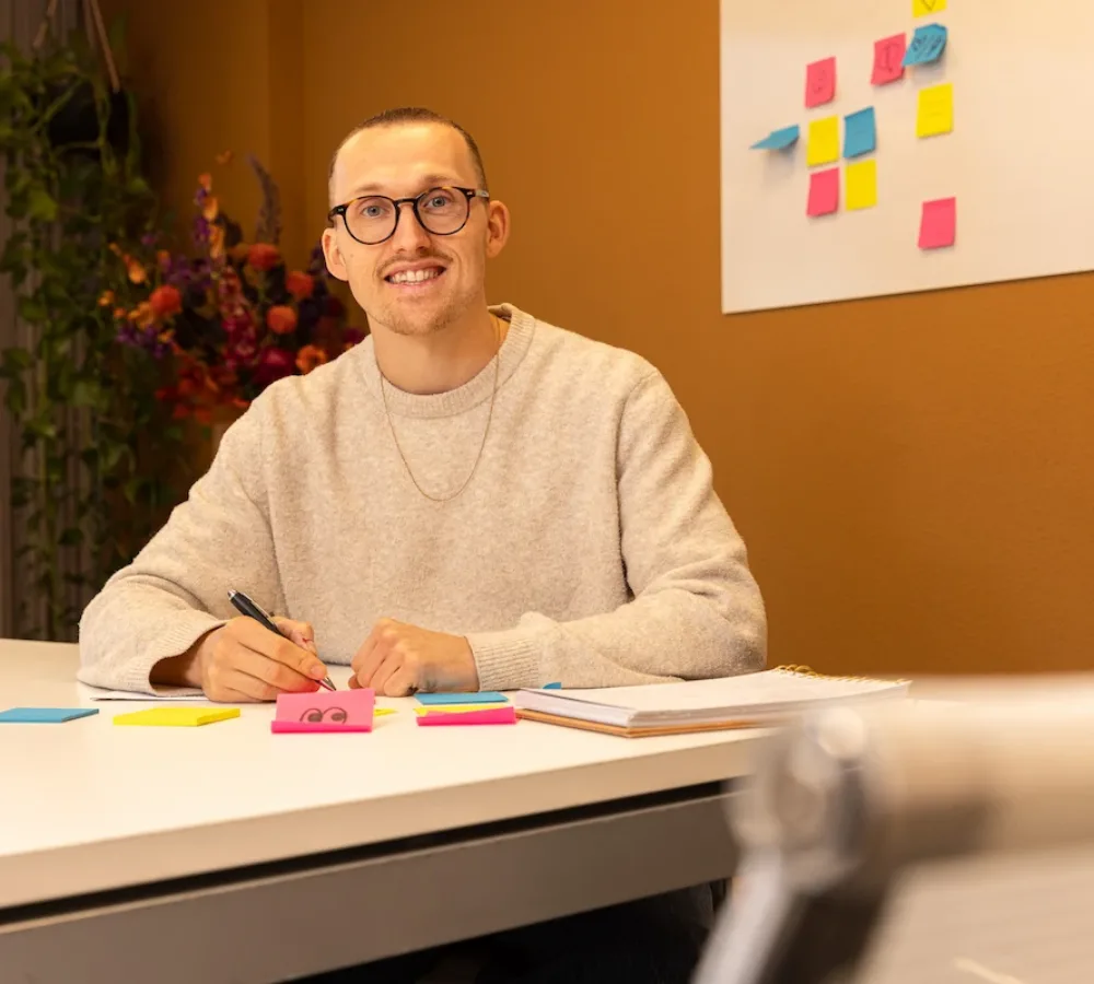 Medewerker van MarketingMakkers werkt met post-its aan tafel