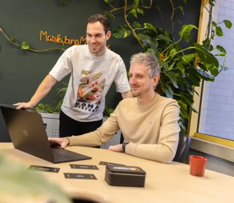 Twee medewerkers van MarketingMakkers werken samen achter laptop