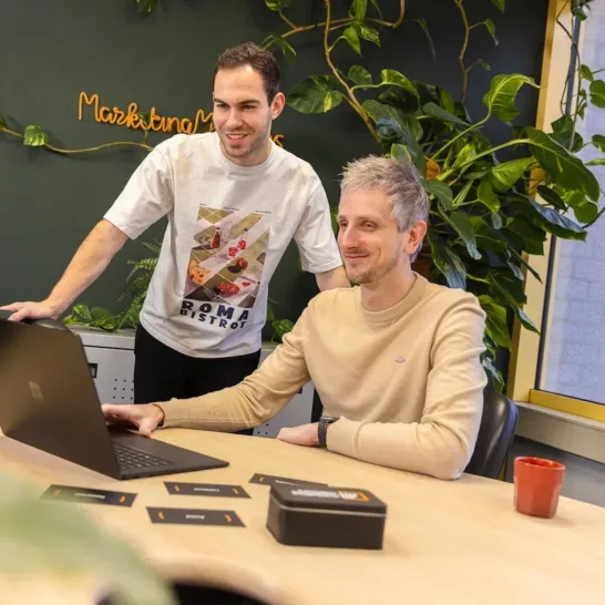Twee medewerkers van MarketingMakkers werken samen achter laptop