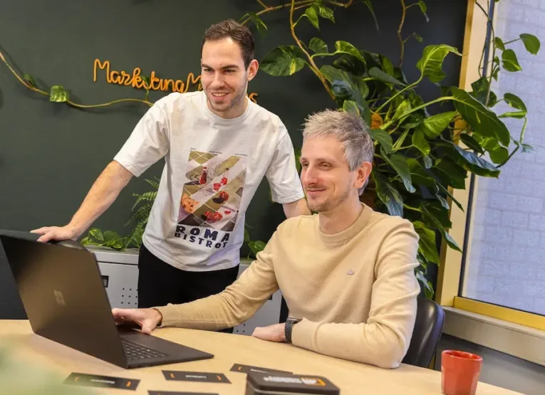 Twee medewerkers van MarketingMakkers werken samen achter laptop