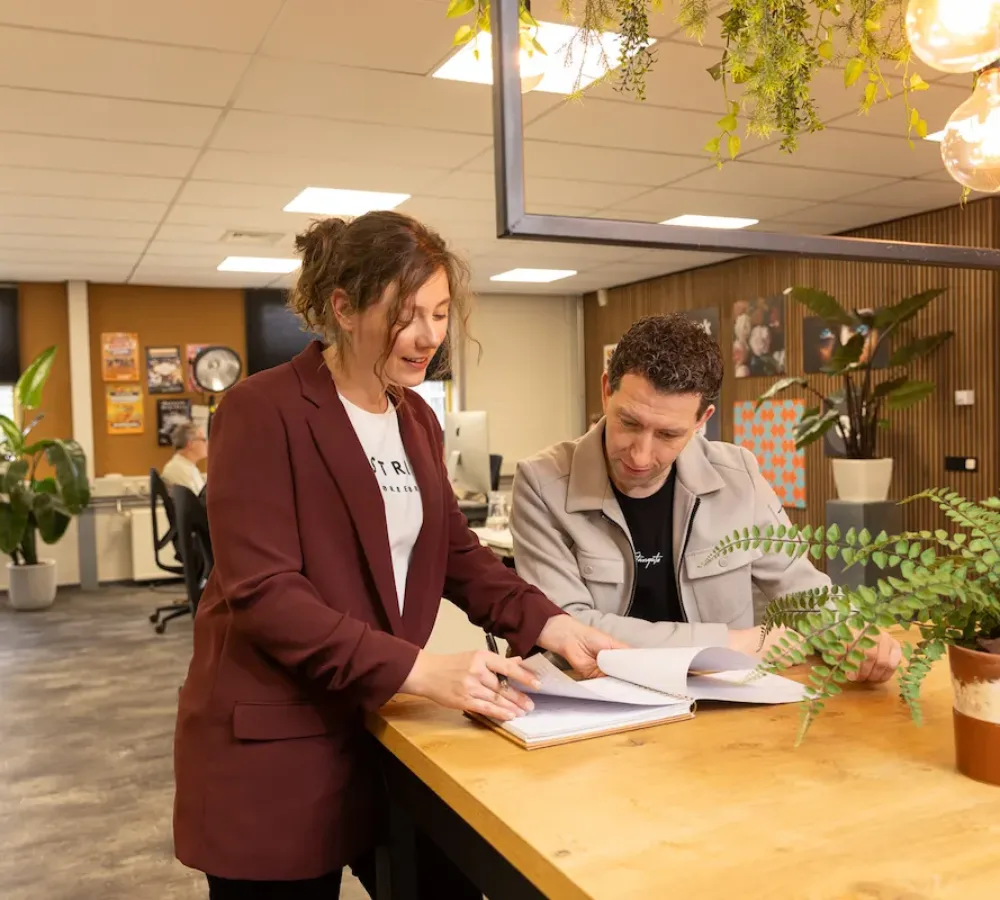 Twee medewerkers van MarketingMakkers bespreken document voor interne communicatie