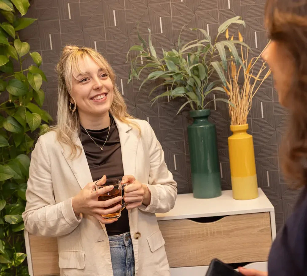 Medewerker van MarketingMakkers in gesprek met theeglas in hand