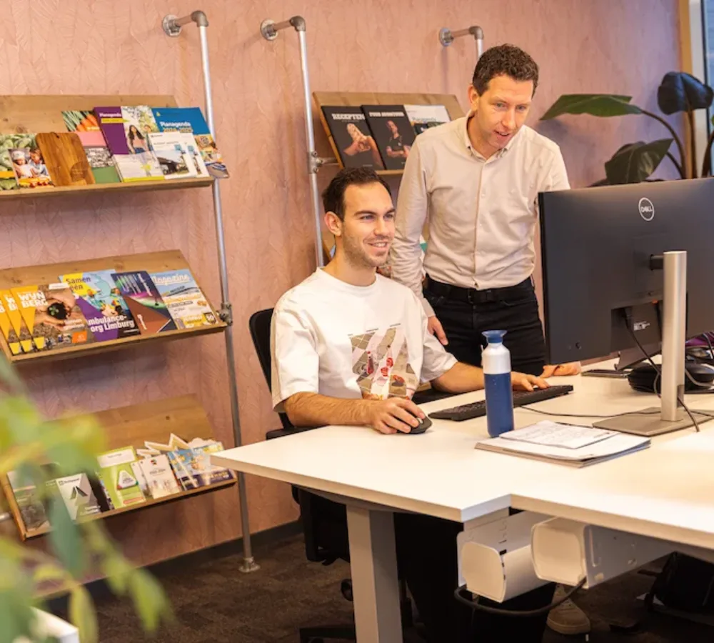 Twee medewerkers van MarketingMakkers werken samen achter computer