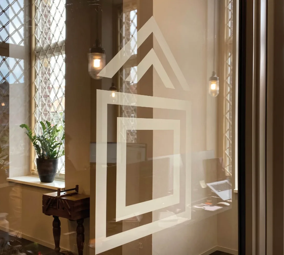 Interieur van ’t Gasthoês met logo op glazen deur